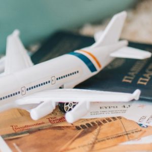 Kleines Plastikflugzeug auf Reiseunterlagen