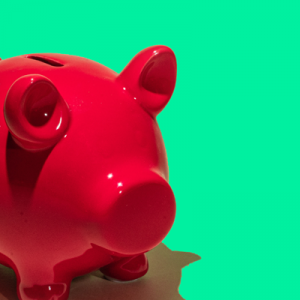 Rotes Sparschwein vor grünem Hintergrund