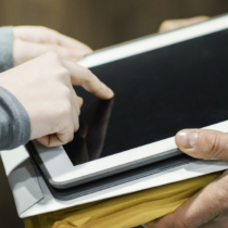 Person unterschreibt auf einem Tablet zur Bestätigung einer Lieferung – typische Anwendung einer einfachen elektronischen Signatur im Alltag.