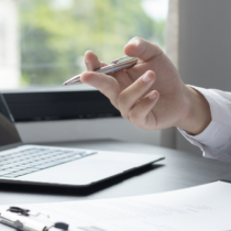 Zwei Personen im Gespräch am Schreibtisch mit Laptop und Unterlagen – symbolisch für digitale Personalverwaltung und moderne HR-Prozesse.