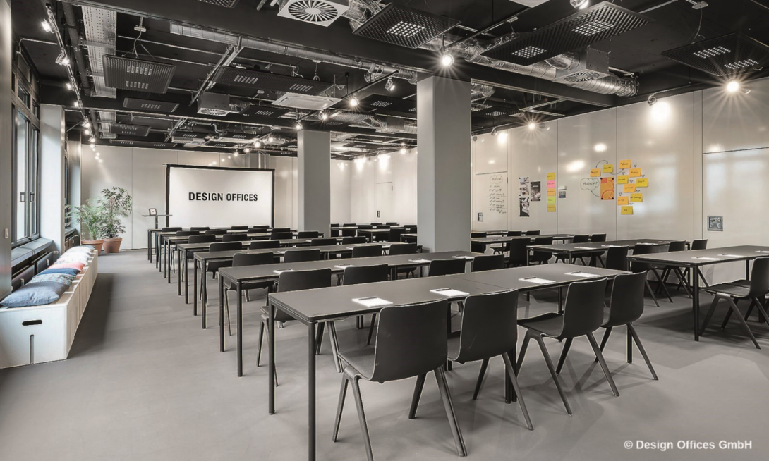 Seminarraum der Design Offices mit Workshop-Tischen und Präsentationsfläche – Ort für Fachvorträge und Kundenprojekte auf der d.velop Discovery Tour 2025