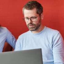 Zwei Mitarbeitende der Verwaltung arbeiten gemeinsam am Laptop und besprechen digitale Lösungen im Rahmen der Verwaltungsdigitalisierung.