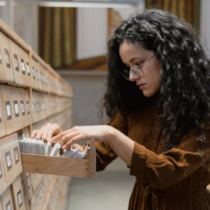 Person durchsucht Archivakten im Rahmen der Aufbewahrungsfrist in der Jugendhilfe und gesetzlicher Archivierungspflichten