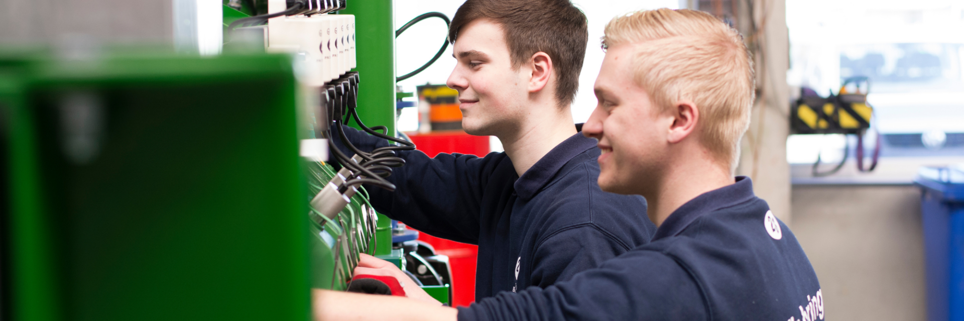 Zwei Mitarbeitende arbeiten an technischen Systemen und greifen über eine Plattformlösung auf zentrale Dokumente zu, um Datensilos abzubauen