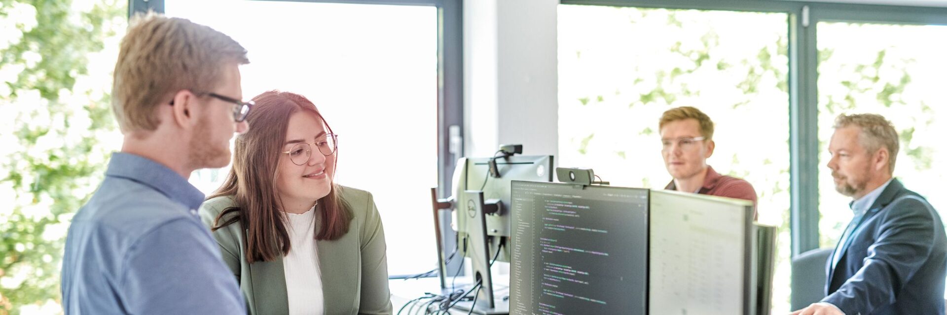 Zwei Mitarbeitende der d.velop AG stehen gemeinsam am Schreibtisch und tauschen sich über die Learnings der AI Week aus.