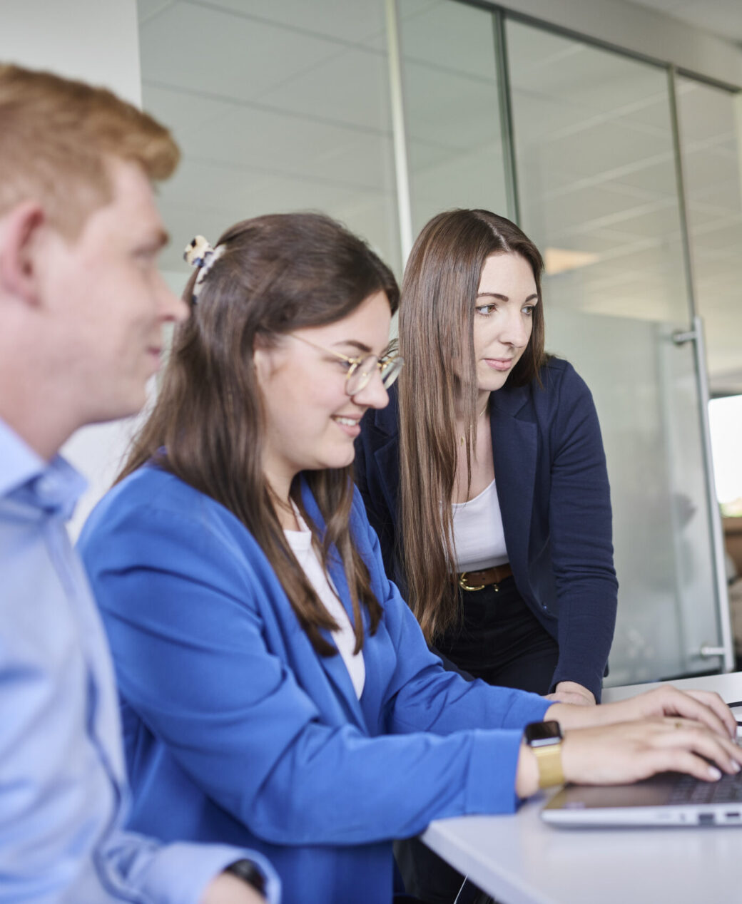 Drei d.velop Mitarbeiter in einer Onboarding-Situation am Arbeitsplatu