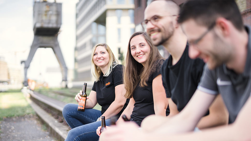 Mitarbeitende sitzen am Hafen mit codia Bier