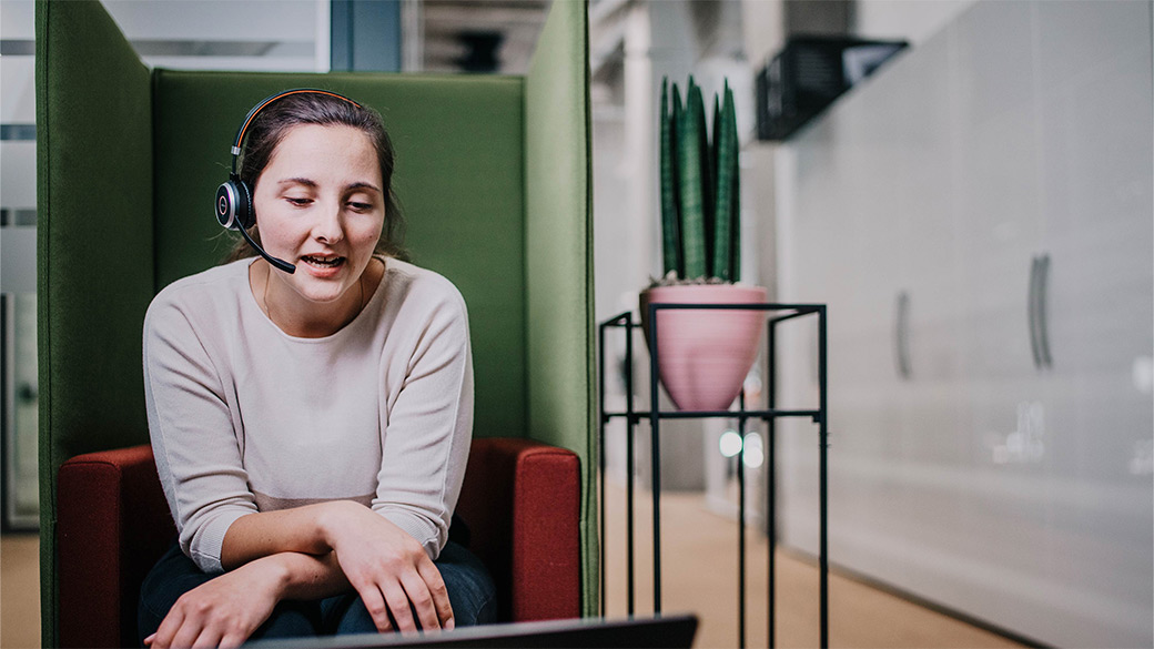 Mitarbeiterin mit Headset am Arbeiten