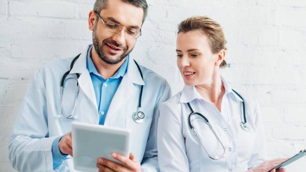 Ärzte mit Tablet auf dem eine digitale Patientenakte aufgerufen wird