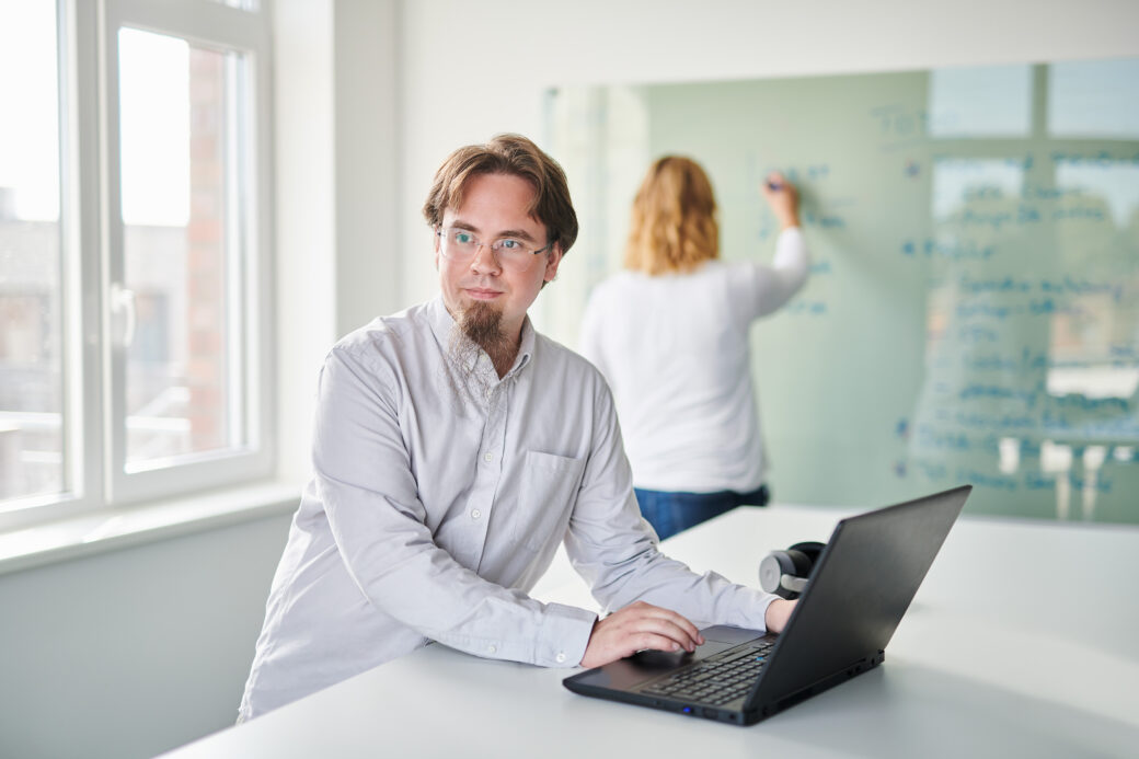 d.velop MItarbeiter steht vor seinem Laptop