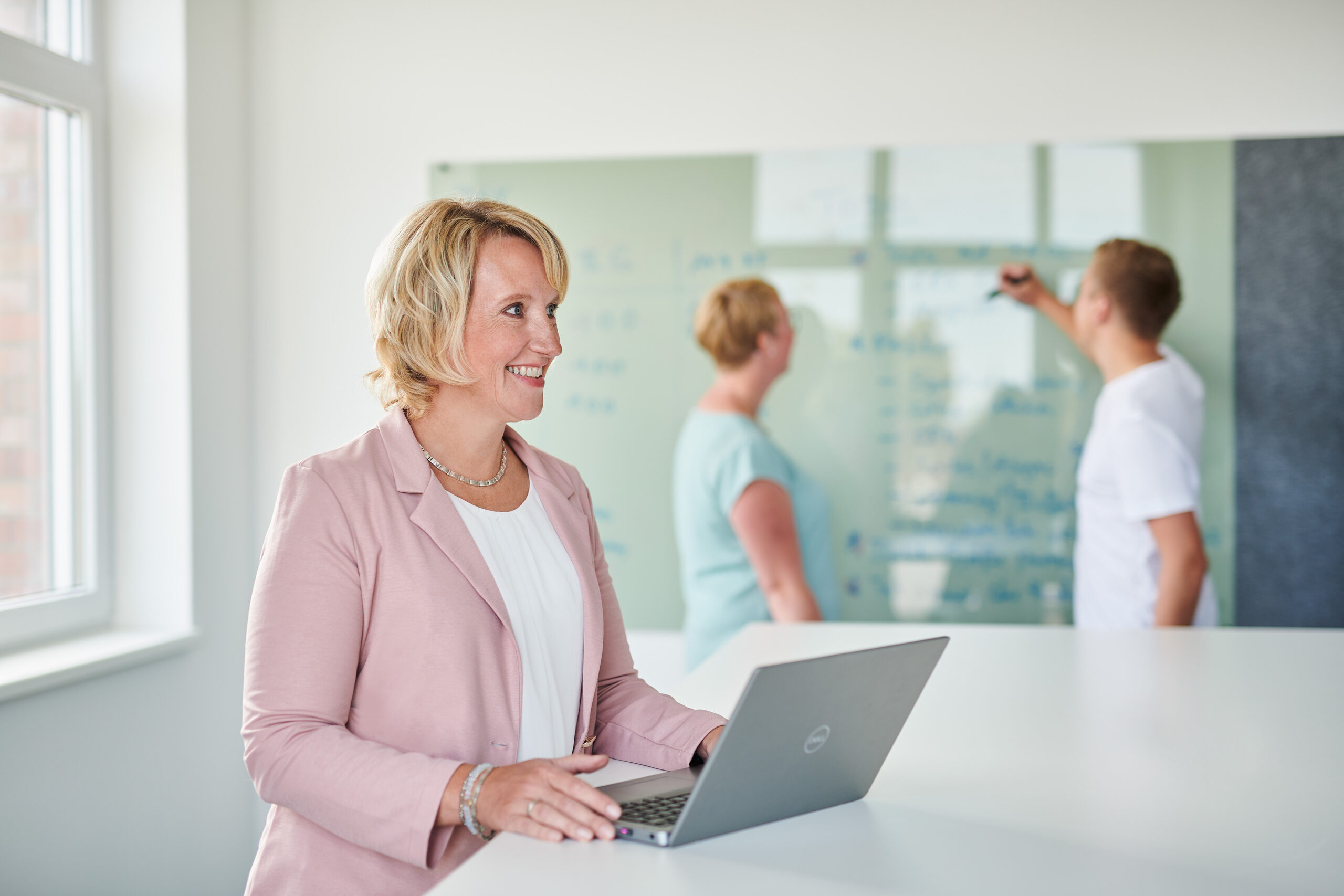 MItarbeiterin arbeitet am Laptop mit einem Vetragsmanagement System