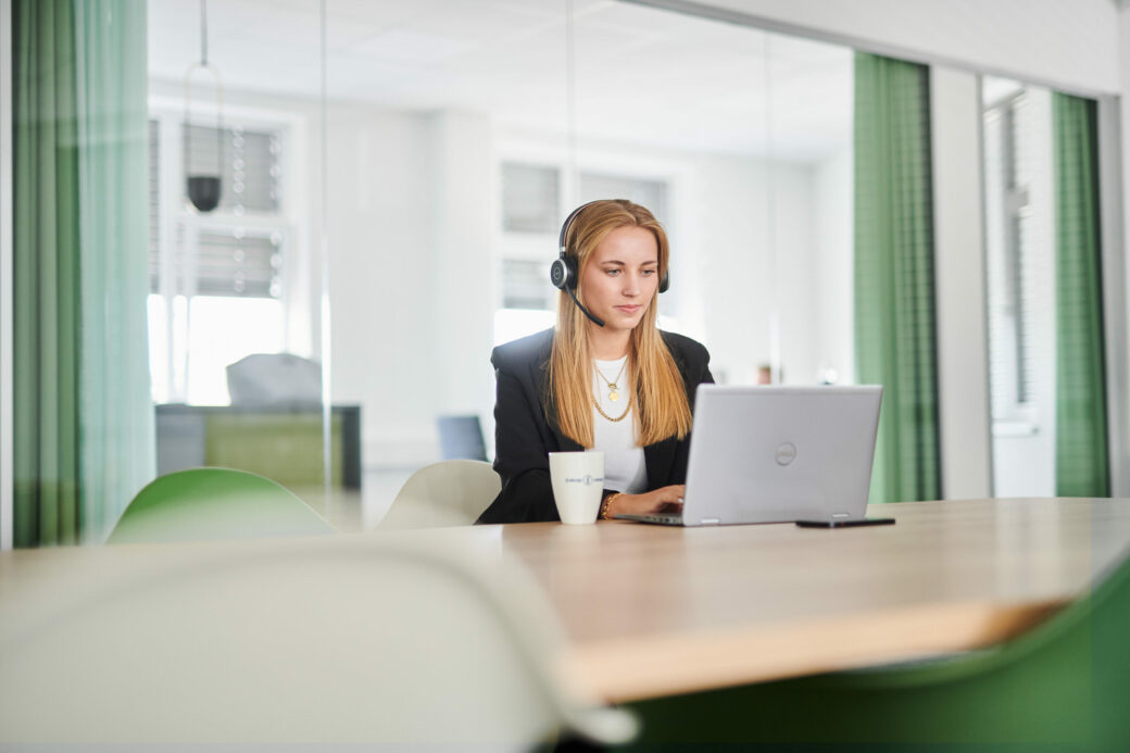 Frau, die vor dem Rechner sitzt und ein Webinar zur SAP Archivierung schaut.